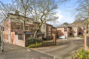 a house on a street with a fence at Grove House - By Sigma Stays in Newcastle under Lyme