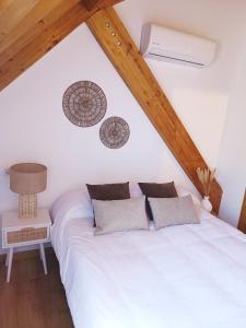 een slaapkamer met een wit bed op zolder bij Duplex El Refugio de La Bolera in Arroyo Frio