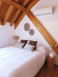 - une chambre mansardée avec un lit blanc dans l'établissement Duplex El Refugio de La Bolera, à Arroyo Frío