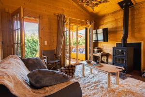 a living room with a couch and a stove at Riverside Forest Retreat-Chalet in Karpenision