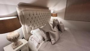 sypialnia z łóżkiem z poduszkami i lampą w obiekcie Little Corners w mieście Shawford