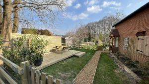 a wooden deck with a bench in a yard at Little Corners in Shawford