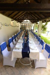 a long table with white tables and blue chairs at Ugostiteljski objekat KARIBO in Sombor