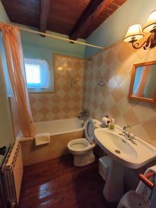 łazienka z umywalką, toaletą i wanną w obiekcie Don Camino Low Cost w mieście Villalcázar de Sirga