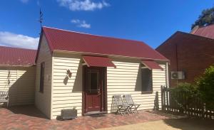 a small white building with a red roof at Bon Accord in Sale