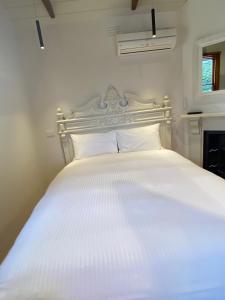 ein Schlafzimmer mit einem weißen Bett mit einer weißen Tagesdecke in der Unterkunft Bon Accord in Sale