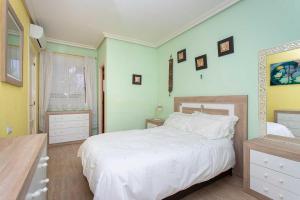 Un dormitorio con una gran cama blanca y una ventana en CH La Paz Los Montesinos, en Los Montesinos