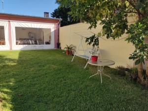 patio ze stołem w trawie w obiekcie Casita Casa con parque, estacionamiento y pileta en Tigre w mieście Tigre