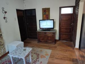 sala de estar con TV en un armario de madera en Casita Casa con parque, estacionamiento y pileta en Tigre en Tigre