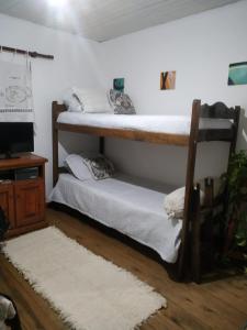 two bunk beds in a room with a television at Casita Casa con parque, estacionamiento y pileta en Tigre in Tigre