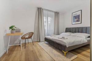 une chambre avec un lit, un bureau et une chaise dans l'établissement 2 BR Apt Steps to Nivy Station, à Bratislava