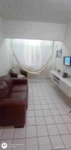 uma sala de estar com um sofá e piso em azulejo em Apt Candeias para 6 pessoas no Recife