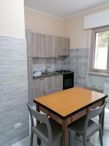 Una cocina con una mesa y sillas de madera. en A casa di nonna Giovanna, en Vasto