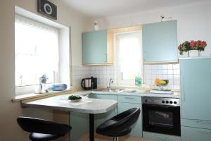 a kitchen with blue cabinets and a counter with stools at Gästehaus Ehses in Bernkastel-Kues