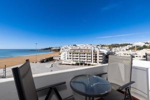 a balcony with a table and chairs and a view of the beach at Apartamentos Pescadores in Albufeira