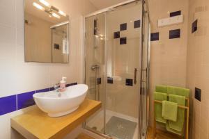 W łazience znajduje się umywalka i prysznic. w obiekcie Apartamentos Pescadores w Albufeirze