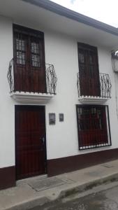 two doors and two balconies on a white building at Hostal la Lomita in Popayan