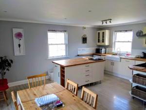 a kitchen with a wooden table and a dining room at Stonebank House in Lamberton