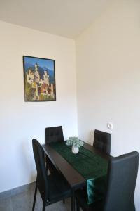uma mesa de jantar com cadeiras e uma foto na parede em Sky Garden, cozy & sweet em Zagreb