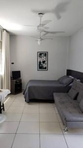 salon z łóżkiem i kanapą w obiekcie Studio Frente à Praia Boqueirão w mieście Santos