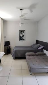 sypialnia z łóżkiem i kanapą w obiekcie Studio Frente à Praia Boqueirão w mieście Santos