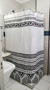 a bathroom with a black and white shower curtain at Studio Frente à Praia Boqueirão in Santos