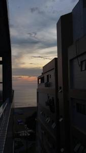 a view of the ocean from between two buildings at Studio Frente à Praia Boqueirão in Santos