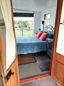 um quarto com uma cama e uma janela em Corner Cottage Rear Studio - Geneva in Kyogle em Kyogle