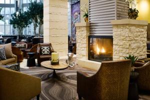 a fireplace in a lobby with chairs and a table at Archer Hotel Austin in Austin