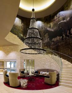 a living room with a chandelier and a staircase at Archer Hotel Austin in Austin