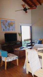 a living room with a bed and a flat screen tv at Casa con pileta en Paso de la Patria in Paso de la Patria