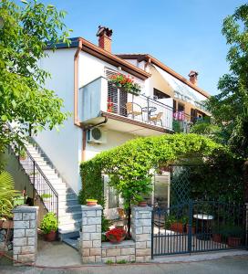 une maison blanche avec des escaliers et un balcon. dans l'établissement Apartment Iva, à Rovinj