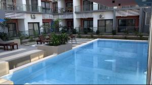 a large blue swimming pool in front of a building at Aqua view Beach Apartment in Banjul