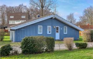 a blue house in a yard with some bushes at Strandpark 6 in Schönhagen