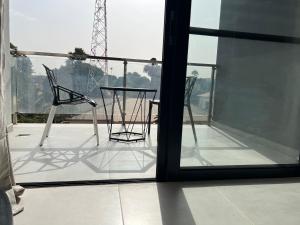 two chairs and a table on a balcony at Aqua view Beach Apartment in Banjul