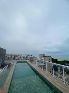 una piscina en la parte superior de un edificio con el océano en Apartamento vista mar em João Pessoa, en João Pessoa
