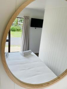 a mirror reflecting a bed in a room at Athenree Hot Springs & Holiday Park in Waihi Beach