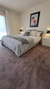 a bedroom with a large bed and a window at Cummins Cottage in Broken Hill