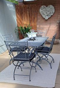 a table and chairs on a patio with a heart at Cummins Cottage in Broken Hill