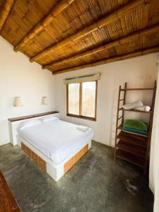 a bedroom with a large bed and a wooden ceiling at Mancora Soul in Máncora