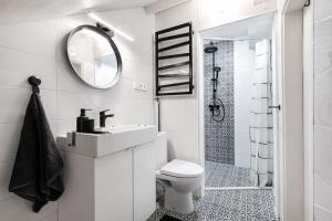 ein Badezimmer mit Toilette, Waschbecken und Spiegel in der Unterkunft Luxury apartment in Gediminas avenue with terrace in Vilnius + 18 Fotos