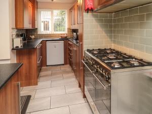 uma cozinha com uma placa de fogão e forno. em Victoria Cottage em Amble