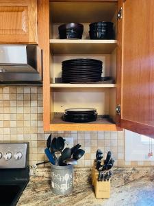 a kitchen counter with plates and utensils in a cabinet at Spacious single family home close to VA and DC 5mins to MGM in Fort Washington