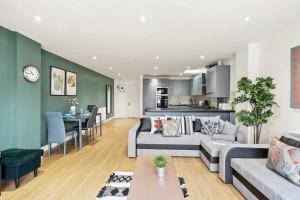 a living room with a couch and a dining room at Elegant Flat - Sleeps 8 in Bristol