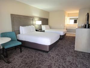 a hotel room with two beds and a table and chair at Grand Legacy At The Park in Anaheim