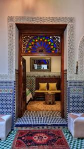 a room with a bench and a stained glass window at Dar La Bague de Kenza in Fès