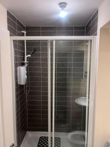 a shower with a glass door in a bathroom at Shelly's Place in Glasgow