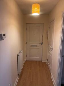 um corredor vazio com uma porta branca e uma ventoinha em Shelly's Place em Glasgow
