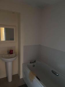 a bathroom with a white tub and a sink at Shelly's Place in Glasgow