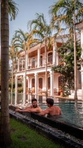 two men in a swimming pool in front of a building at Villa Canziani & Donato in Pôrto de Pedras +160 photos